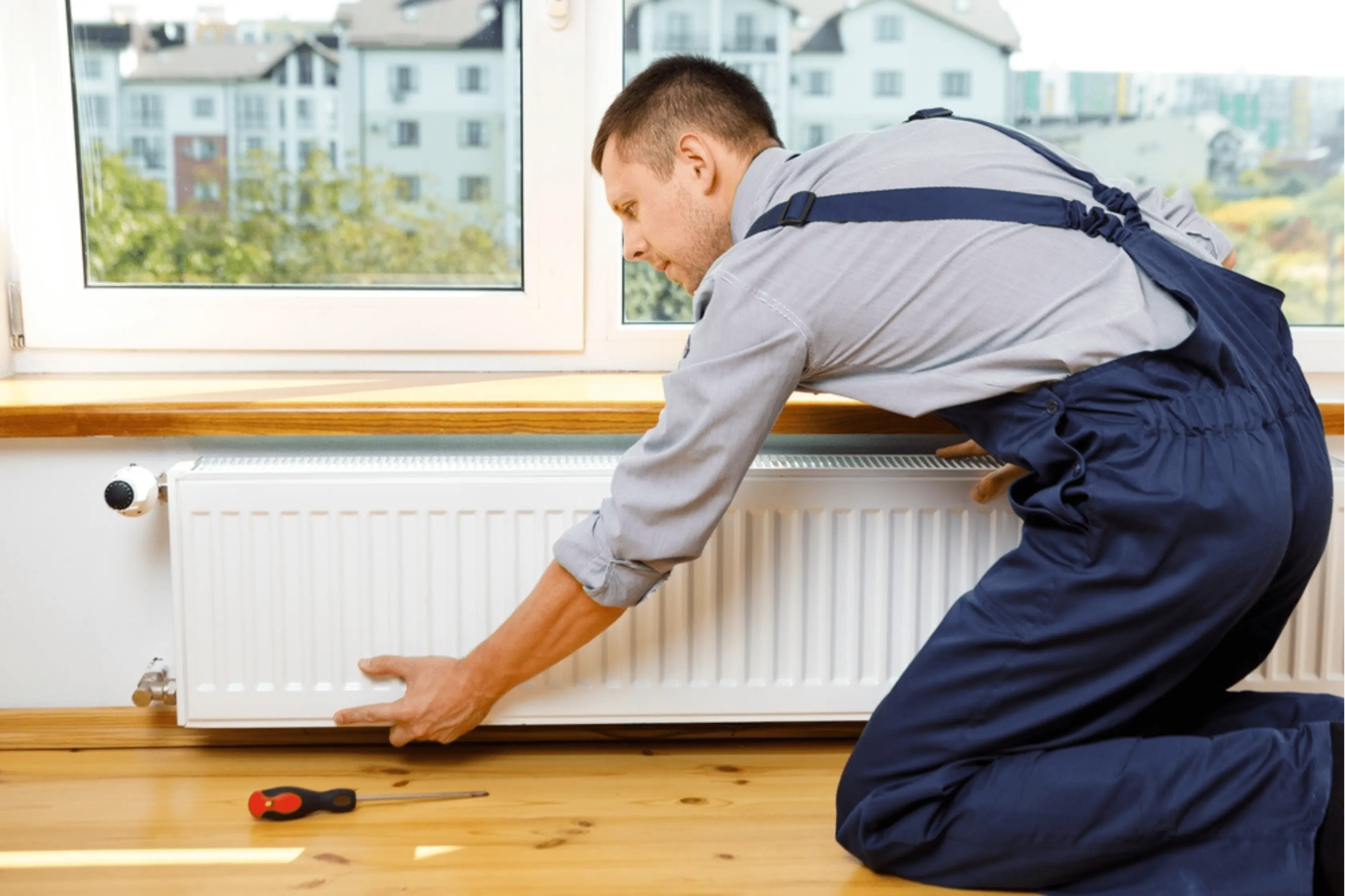 Plumber Removing Radiator From Homeowners Wall